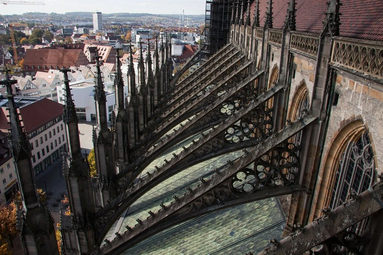 Flying buttresses are one of the most iconic features of Gothic architecture style of masonry building characterized by cavernous spaces with the expanse of walls broken up by overlaid tracery . flying buttress