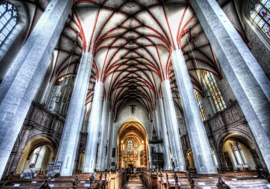 Flying buttresses are one of the most iconic features of Gothic architecture style of masonry building characterized by cavernous spaces with the expanse of walls broken up by overlaid tracery . Architectural significance